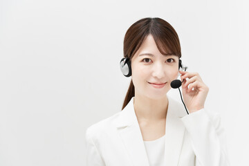ヘッドセットを装着した白いスーツの女性