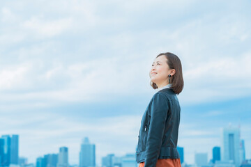 空を見上げるカジュアルな服装のビジネスウーマン