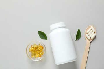 White bottle on a gray background. Fish oil tablets. Biologically active additives. Omega 3, 6, omega 9, vitamin A, E, D,