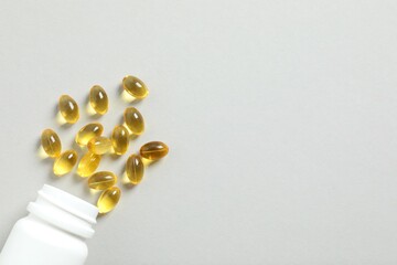 White bottle on a gray background. Fish oil tablets. Biologically active additives. Omega 3, 6, omega 9, vitamin A, E, D,