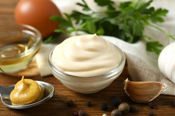 Bowl with mayonnaise and ingredients for cooking on wooden background