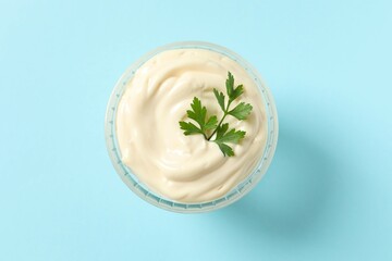 Bowl with mayonnaise on color background