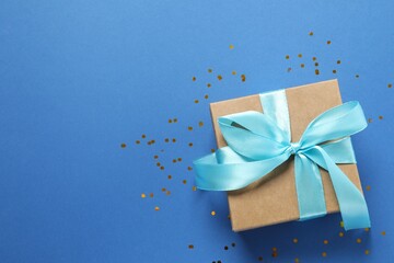 Beautiful gift box tied with bow on color background 