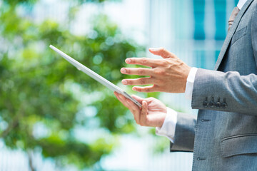 タブレットPCの画面を見るビジネスマン 