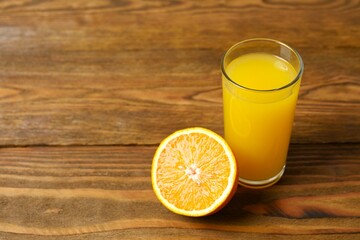 Glass of freshly squeezed orange juice on the table with citrus fruits