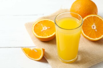 Glass of freshly squeezed orange juice on the table with citrus fruits