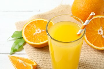 Glass of freshly squeezed orange juice on the table with citrus fruits