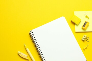 Flat lay with notebook and school stationery on color background, top view