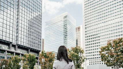 オフィス街にいるスーツ姿の女性（ビジネスイメージ）