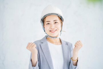 ヘルメットをかぶったスーツ姿の女性