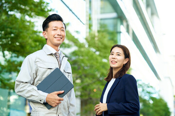 作業着の男性とスーツ姿の女性