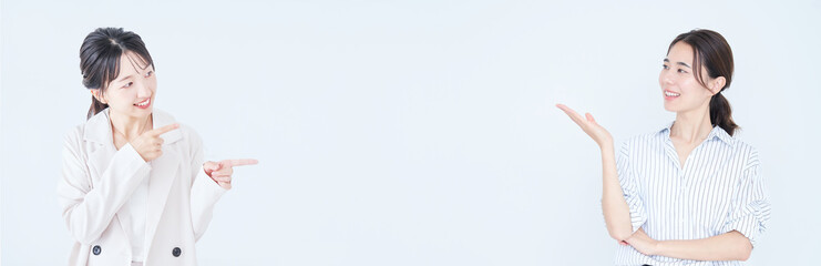 余白を指し示すビジネスウーマンたち