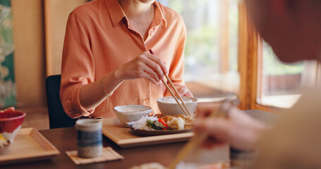 Family, food or eating with chopsticks at dinner table for meal, snack or cuisine at home. Japan, hands and people tasting ingredients with utensils for dining culture, tradition or heritage at house