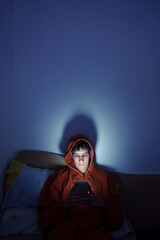 Young man using smartphone in dark room at night © Javier Zayaz