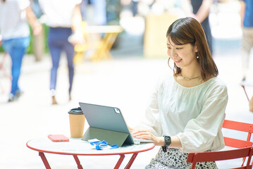 屋外でPC操作をする女性