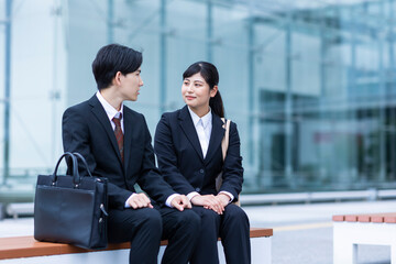 ベンチに座って話す男女