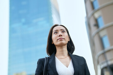 空を見上げるビジネスウーマン