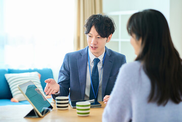 女性に向かって話すスーツ姿の男性