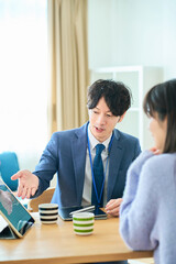 女性に向かって話すスーツ姿の男性