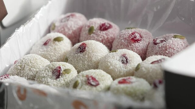 상자안에나란히놓여있는동그란쌀떡포커스이동(떡+경단+간식+음식+포장+잣+견과류+한국+전통)