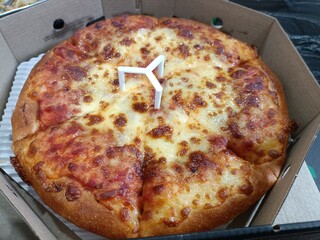 Pizza with ham and cheese in the box. Close up.
