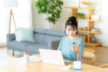 リビングでスマホを操作する女性