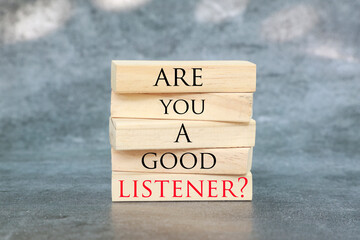 Listening skills symbol written on Wooden blocks with words Are you a good Listener. Beautiful grey...