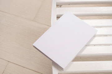 blank book cover mockup on wooden outdoor table, hotel balcony or terrace