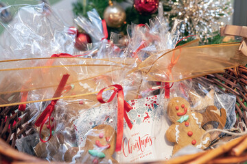Christmas handmade gingerbread cookies in wooden basket, classic man shaped cake packed with red bow. Christmas composition with gingerbread men. Gingerbread man cookies in gift package