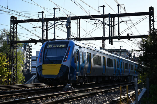 Rear view of a High Capacity Metro Train, or HCMT, heading to Flinders Street in the city of Melbourne late in the afternoon