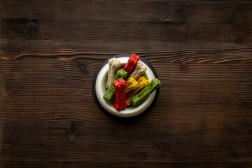 Bowl full of chew bones for dog. Food and treats for pets