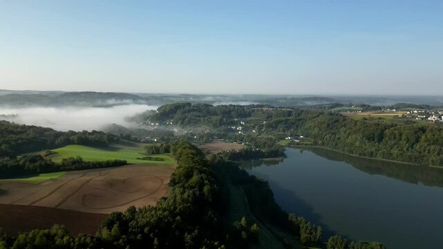 The Brodno Wielkie Lake and the village of Brodnica Dolna shrouded in fog in the background. Kashubia, Poland.