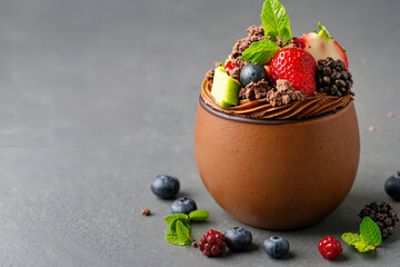 A chocolate dessert with berries and mint leaves on top