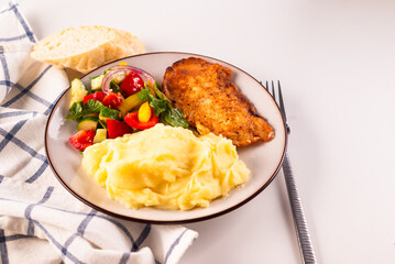 Fried chicken steak or schnitzel with mashed potatoes and vegetables salad in plate