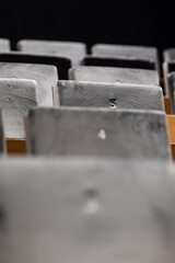 Rows of empty seats in a cinema hall,  front side of the seats with numbers. Close-up with shallow depth of field