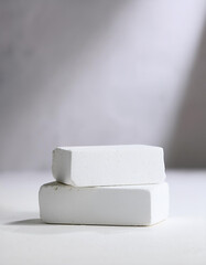 Two white stone blocks, empty podium. Pedestal for product presentation. Mock-up. Light backdrop
