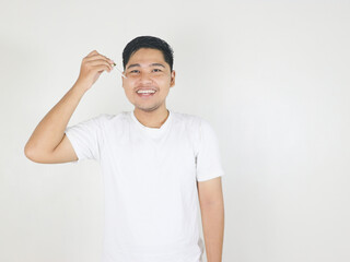 portrait of handsome guy applying serum beauty product on his face using glass pipette