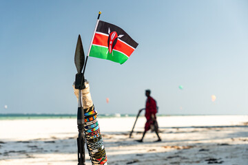 The spear of Masai and national flag of Kenya on the background of a beautiful beach landscape. the...