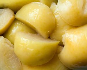 Close-up of yellow canned apple slices. Sweet natural fruits.