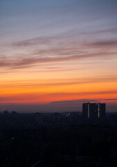 Silhouettes of urban buildings during sunset with dramatic clouds. Evening cityscape photography