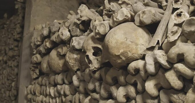 Ancient Human Skulls and Bones Arranged in Historic Paris Catacombs Underground Ossuary. Haunting Close-up Documentary Footage of Famous French Underground Cemetery with Authentic Medieval Remains