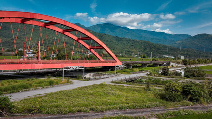 Fototapeta premium Kecheng Iron Bridge spans lush landscape in Taiwan under a clear blue sky during daytime