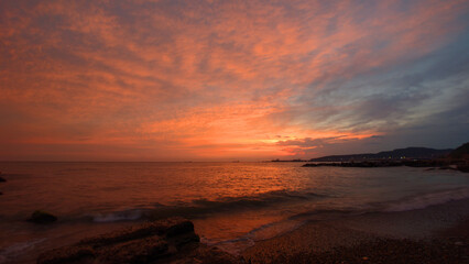 A serene scene of sunset on a peaceful beach, ideal for use in travel or leisure brochures.