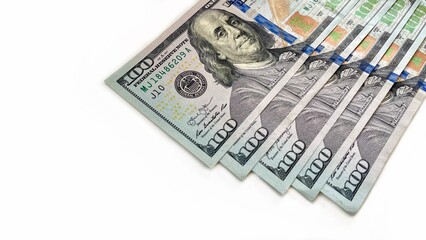 A fanned arrangement of 100 U.S. bills on a clean white background, symbolizing wealth, finance,...