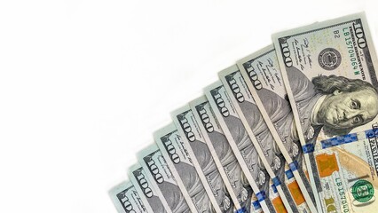 A fan-shaped arrangement of 100 U.S. bills on a clean white background, symbolizing financial...