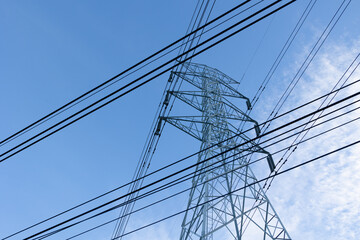 electricity transmission pylon silhouetted against blue sky at dusk