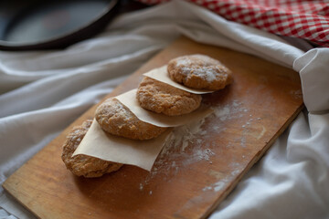 Homemade vegan patties placed on a rustic wooden board with parchment paper, styled in a cozy kitchen setting. Warm natural light highlights the texture, ideal for food photography or plant-based meal