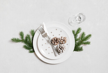 Festive table setting for Christmas dinner with silver cutlery on white background. View from above.