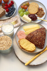 Assortment of various breakfast foods and drinks on the white table. Selective focus.