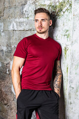 Fototapeta premium Junger Mann in Sportkleidung trainiert mit Sportgeräten im Fitnessstudio konzentriert und motiviert